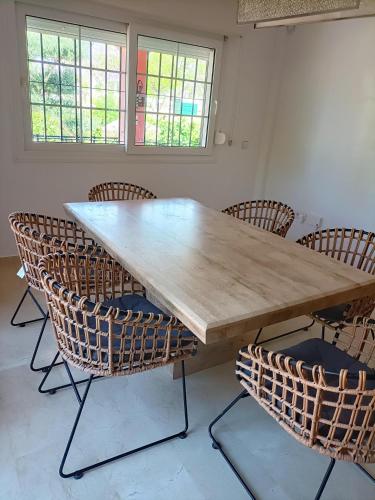 a large wooden table with chairs around it at Villa Matisse Luxury Beach in Torremolinos