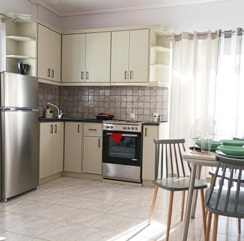 a kitchen with white cabinets and a stainless steel refrigerator at Athani Summer House (Apartments 01 - 02) in Athanion