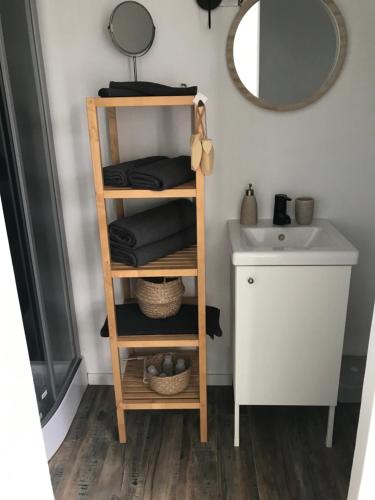 - une salle de bains avec une étagère en bois à côté d'un lavabo dans l'établissement Le cabanon détente, à Bandol