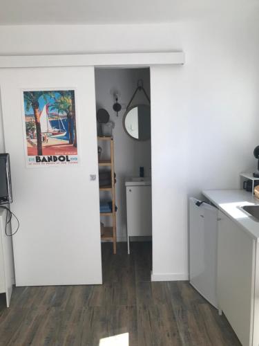 Il comprend une cuisine avec des murs blancs et du parquet. dans l'établissement Le cabanon détente, à Bandol