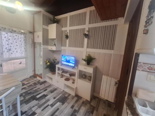 a living room with a television and white cabinets at La Casita in Gijón