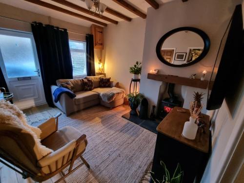a living room with a couch and a mirror at Bow Cottage in Abercraf