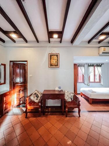 a bedroom with a bed and a table in a room at khong kham Hotel in Luang Prabang
