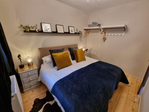 a bedroom with a large bed with yellow pillows at Bow Cottage in Abercraf