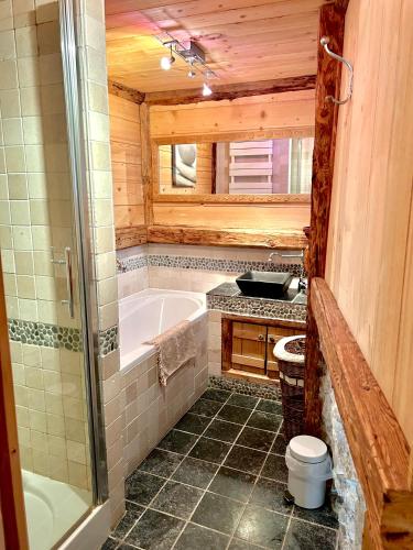 une salle de bain avec une baignoire et un lavabo dans l'établissement Chalet l'Oréade, à Saint-Gervais-les-Bains
