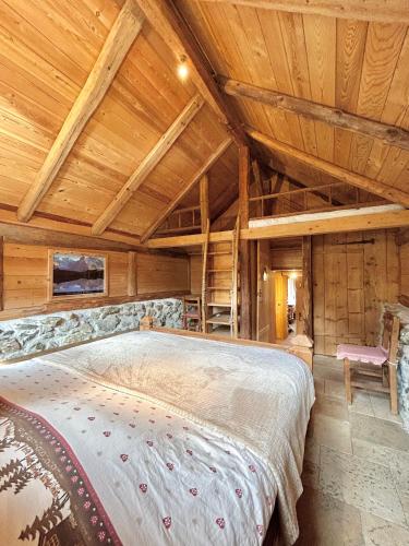 - une chambre avec un grand lit au plafond en bois dans l'établissement Chalet l'Oréade, à Saint-Gervais-les-Bains