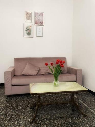 a couch and a table with a vase of flowers on it at Appartamento Sea La Vie in Genova