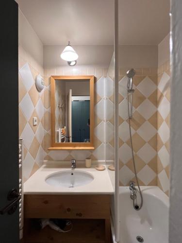 une salle de bain avec un lavabo, un miroir et une baignoire dans l'établissement La Plagne Appartement au pied des pistes avec vue Mont Blanc, à La Plagne Tarentaise
