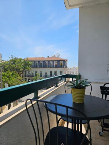 a table and chairs on a balcony with a view of a building at Casa Jasmim in Faro