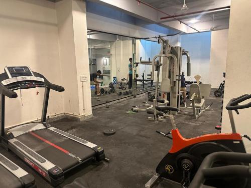 una habitación con gimnasio con cinta de correr y pesas en Ivy League House, Pyramid Residency, en Nueva Delhi