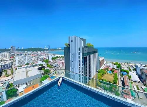 a person standing on the edge of a swimming pool on a building at 2 Bed Room, Large Living Room @ Central Pattaya in Pattaya