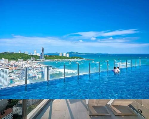a pool on top of a building with a view of the ocean at 2 Bed Room, Large Living Room @ Central Pattaya in Pattaya