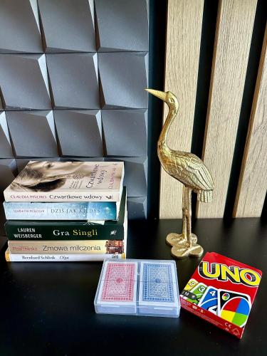 a gold bird statue sitting next to a stack of books at Blisko Gór Szyndzielnia in Bielsko-Biala