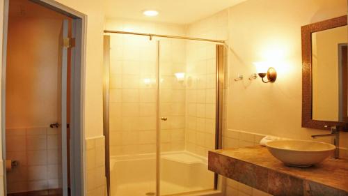 La salle de bains est pourvue d'une douche en verre et d'un lavabo. dans l'établissement Blue Horizon, à Humacao