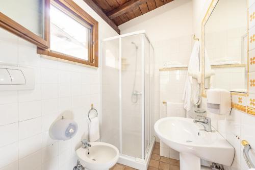 uma casa de banho branca com um lavatório e um chuveiro em Holiday Village em Fondi