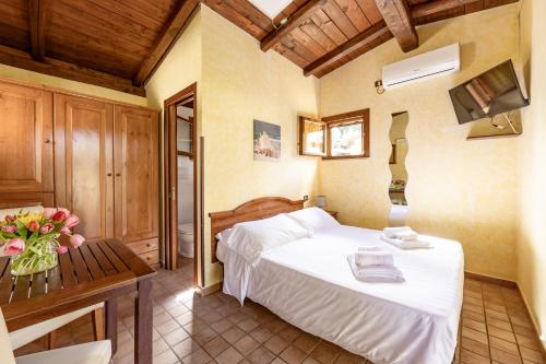 a bedroom with a bed and a table with a vase of flowers at Holiday Village in Fondi