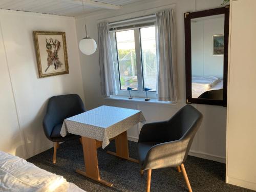 a room with a table and two chairs and a mirror at Skagen Annex Apartment in Skagen