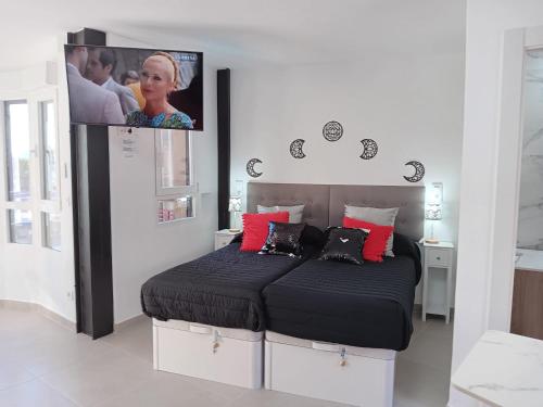 a bedroom with a bed with a tv above it at COBLANCA 5-STUDIO EXCLUSIVO in Benidorm