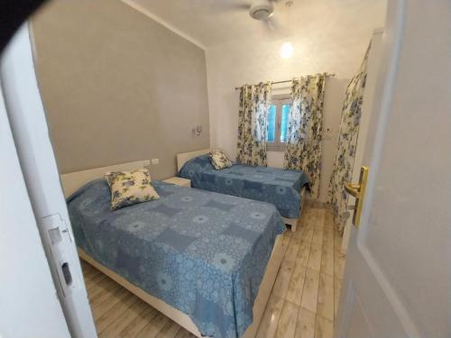 1 dormitorio con 2 camas y ventana en desert pearl beautiful cosy new home en Luxor