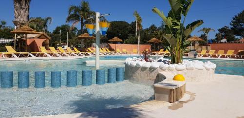 une piscine dans un complexe avec des chaises longues et une piscine dans l'établissement CAMPING RÊVE DES ILES, à Argelès-sur-Mer