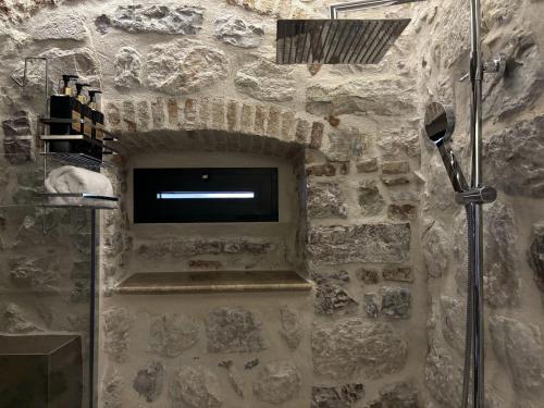 a bathroom with a shower in a stone wall at KAŽIN supreme in Kotor