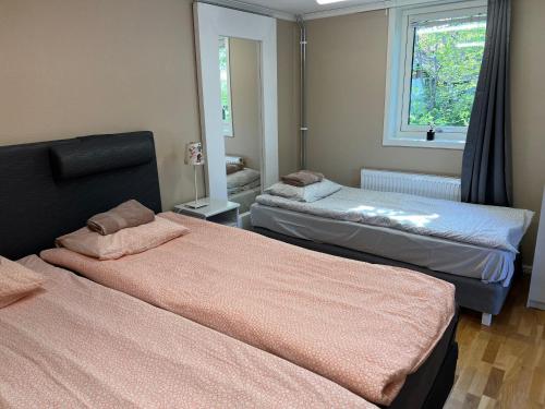 a bedroom with two beds and a window at Egen lägenhet i charmig miljö i Linköping V in Vikingstad