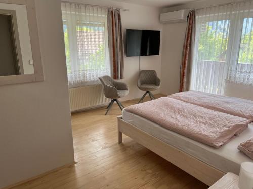 a bedroom with a bed and two chairs in it at Rooms Hrominc in Bled