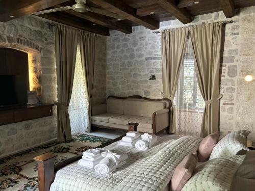 1 dormitorio con 2 camas y sofá en KAŽIN supreme en Kotor