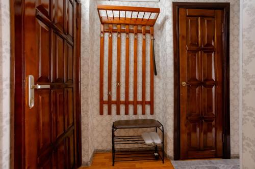 a hallway with two wooden doors and a chair at 2-х комнатная квартира в центре города по ул.Тәуелсіздік 70 in Kostanay