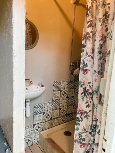 une salle de bain avec un lavabo et un rideau de douche dans l'établissement Tente lodge en pleine nature, à Sumène