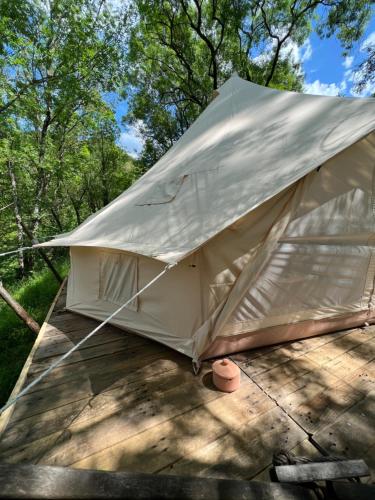 une tente sur une terrasse avec des arbres en arrière-plan dans l'établissement Tente lodge en pleine nature, à Sumène