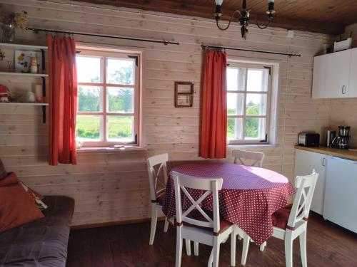 een keuken en eetkamer met een tafel en stoelen bij A cozy cottage where you can enjoy the peace of the countryside in Salacgrīva