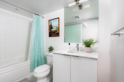 a white bathroom with a toilet and a sink at 2 Beds - Sleeps 3 beside U of T! in Toronto