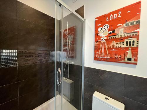 罗兹Apartament I LOVE PIOTRKOWSKA z wielkim lustrem, balkonem i klimatyzacją的浴室设有淋浴,墙上有绘画作品