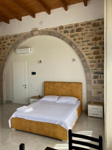 una camera con un grande letto in un muro di mattoni di Hotel Guri Shengjin a Lezhë (Alessio)