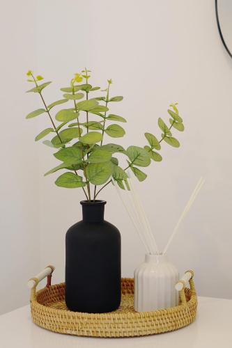 a black vase with a plant in a basket at Seapoint- Boho Coastal Retreat near Sandbanks! in Poole