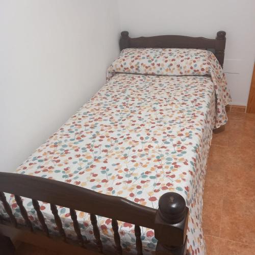 a bedroom with a bed with a comforter on it at Apartamento completo NERUDA in Carboneras