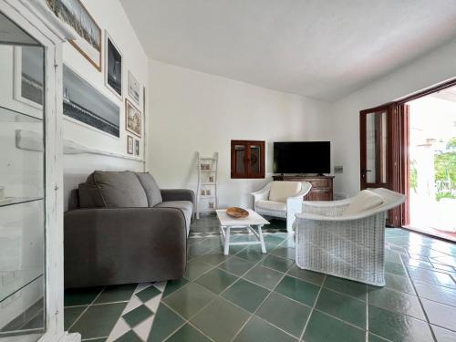 a living room with a couch and a tv at Villa Peru in Tanaunella