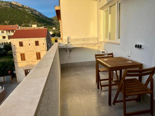 a balcony with a table and chairs and a sink at Newly Refurbished Komiza Haven in Komiža