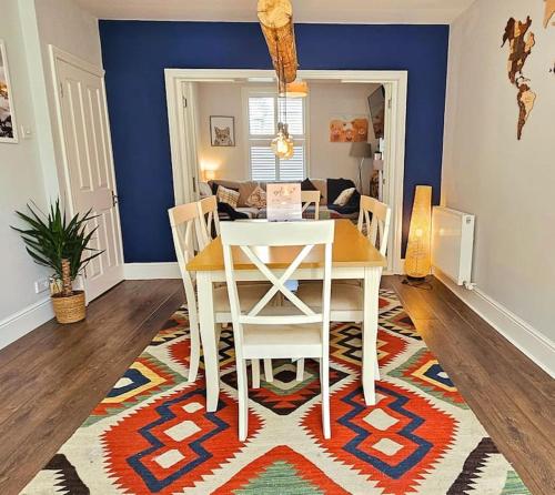 a dining room with a table and chairs on a rug at Stunning terraced house next to York Racecourse in York