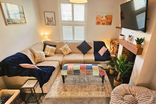 a living room with a couch and a tv at Stunning terraced house next to York Racecourse in York
