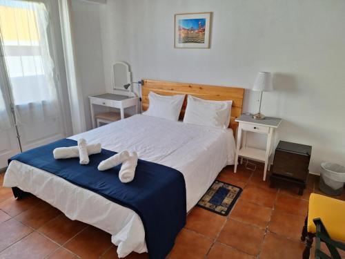 a bedroom with a bed with two towels on it at Adamas Bed & Breakfast in Ponta Delgada