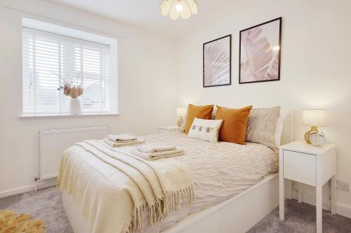 a white bedroom with a bed and a window at Seapoint- Boho Coastal Retreat near Sandbanks! in Poole