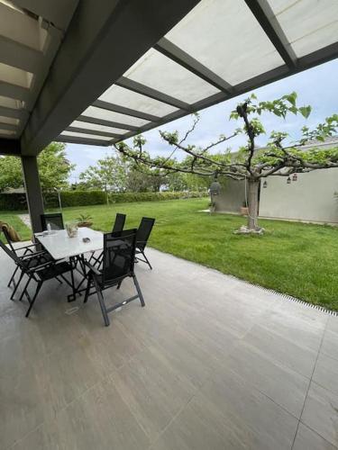 a patio with a table and chairs under a roof at Luxury Villas 3 in Nei Poroi