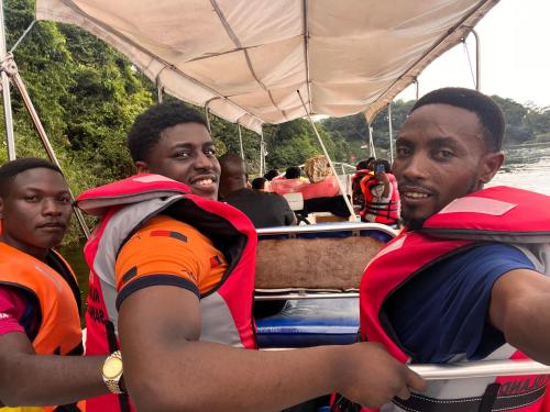 un grupo de hombres llevando mochilas en un barco en Roots cottages and campsite, 