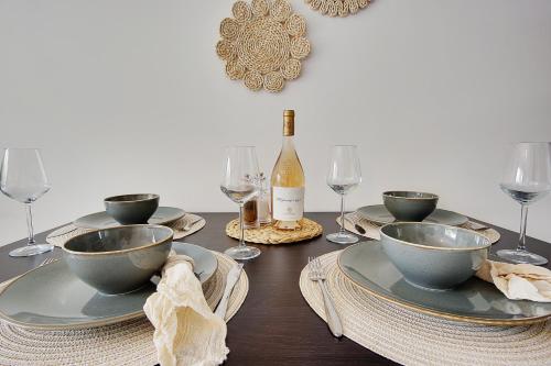 a wooden table with a bottle of wine and glasses at Seapoint- Boho Coastal Retreat near Sandbanks! in Poole