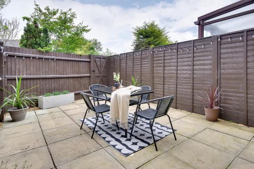 a patio with a table and chairs and a fence at Seapoint- Boho Coastal Retreat near Sandbanks! in Poole