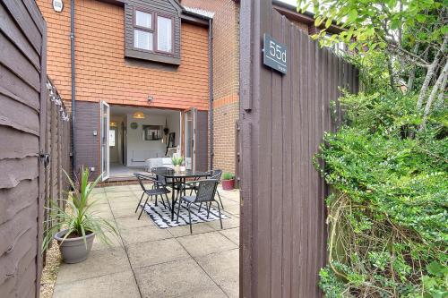a patio with a table and chairs next to a building at Seapoint- Boho Coastal Retreat near Sandbanks! in Poole