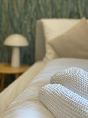 a white bed with a pillow and a lamp on a table at DoreyHome P3 - Modernes charmantes Apartment in Passau