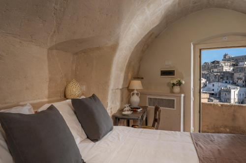 a bedroom with a bed and a view of the city at Locanda Di San Martino Hotel & Thermae Romanae in Matera